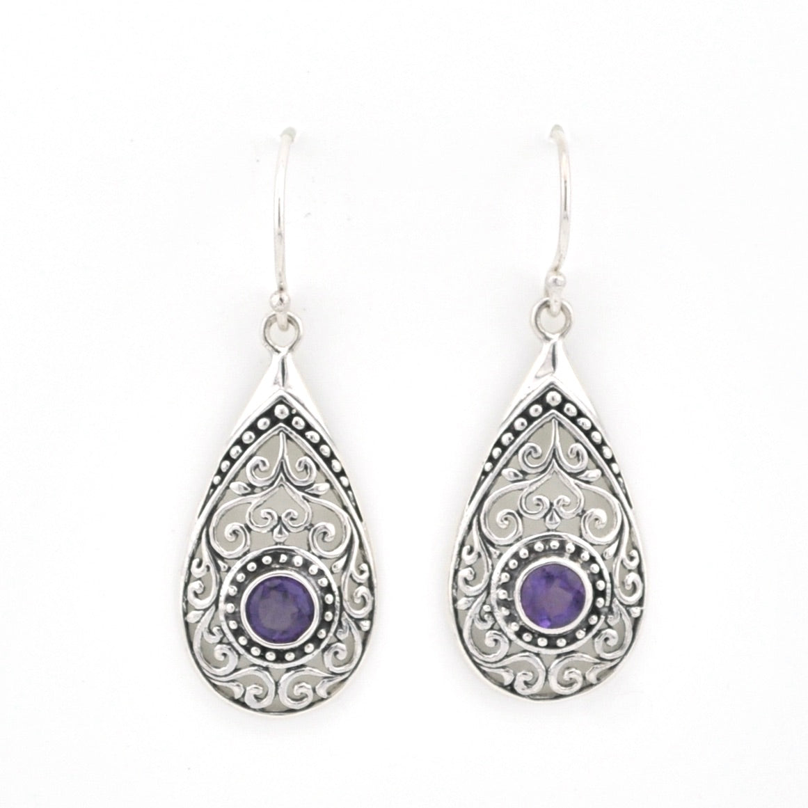 Teardrop-shaped silver earrings with purple gemstones on a white background