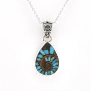 A silver teardrop pendant necklace featuring a turquoise and brown spiral inlay, suspended from a delicate silver chain against a plain white background.
