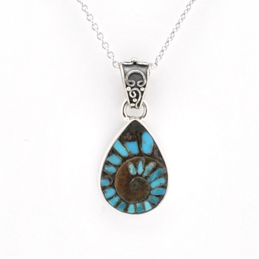 A silver teardrop pendant necklace featuring a turquoise and brown spiral inlay, suspended from a delicate silver chain against a plain white background.
