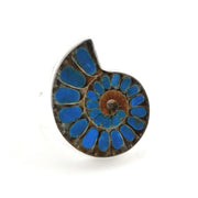 A spiral-shaped ring featuring a detailed ammonite fossil pattern with vibrant blue inlay stones and a brown center, set in a silver-toned metal, shown on a plain white background.