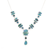 A silver Y-shaped necklace featuring irregular blue-green opal stones and small dark round beads, displayed on a clean white background.