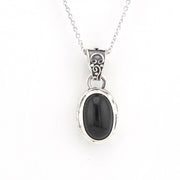 A silver pendant necklace featuring an oval black onyx stone in a decorative silver bezel, suspended from a delicate silver chain against a plain white background.