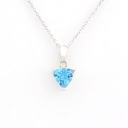 A silver necklace with a trillion-shaped light blue gemstone pendant, displayed against a clean white background.