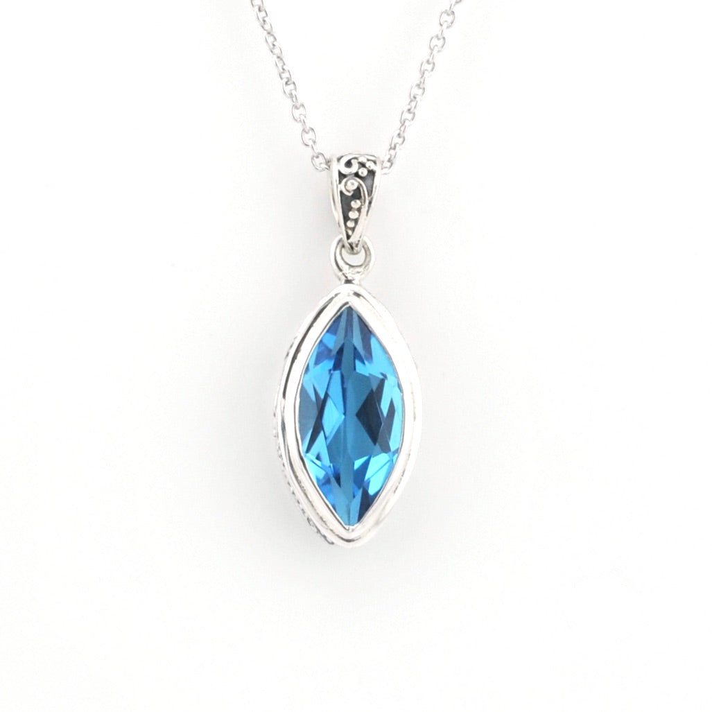 A silver pendant necklace featuring a marquise-cut blue gemstone in a silver bezel setting, suspended from a delicate silver chain against a plain white background.