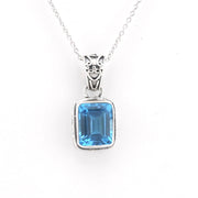 A silver pendant necklace featuring a rectangular emerald-cut blue gemstone in a silver bezel setting, suspended from a delicate silver chain against a plain white background.