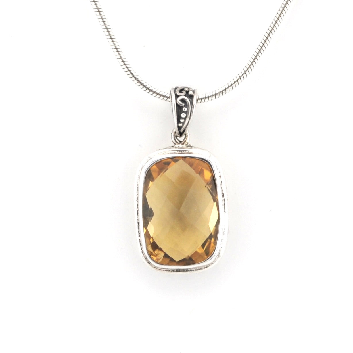 A silver pendant necklace featuring a rectangular faceted yellow gemstone in a silver bezel setting, suspended from a silver snake chain against a plain white background.