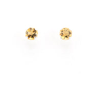A pair of round-cut yellow gemstone stud earrings on a plain white background.