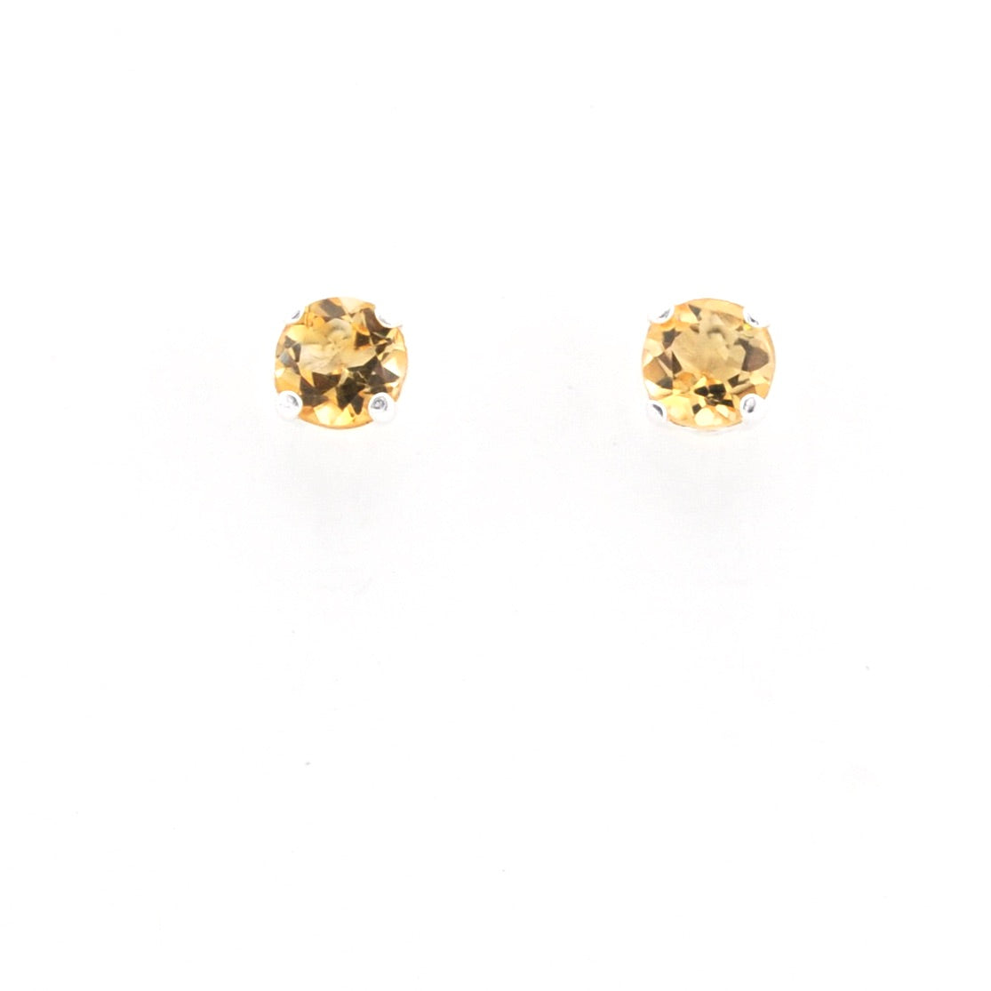 A pair of round-cut yellow gemstone stud earrings on a plain white background.