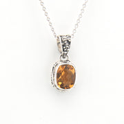 Silver pendant with a yellow gemstone on a white background