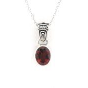 Silver pendant with a red gemstone on a white background