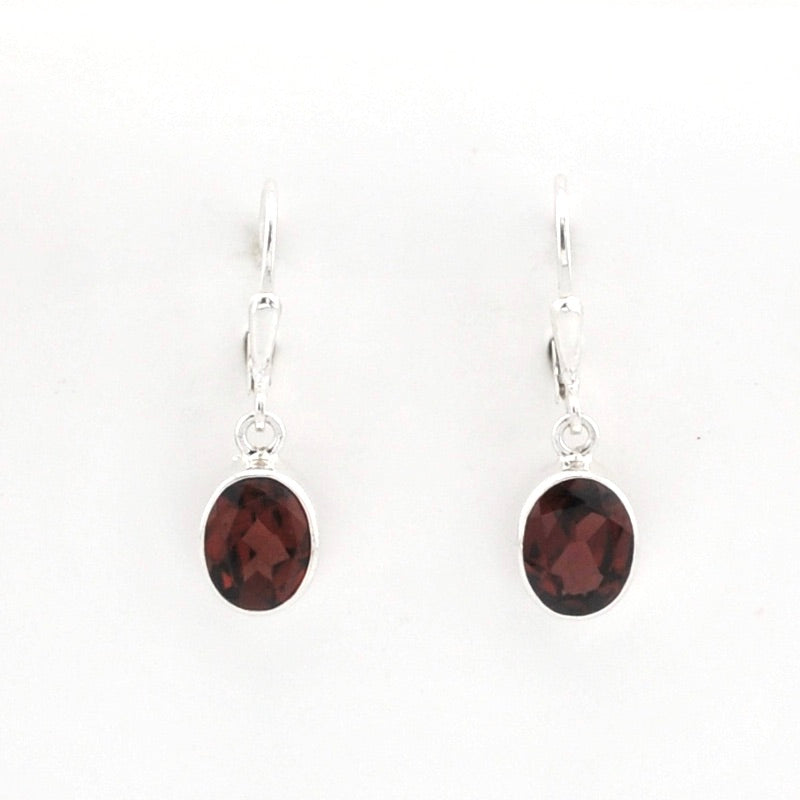 A pair of silver drop earrings with oval dark reddish-brown gemstones, shown on a plain white background.