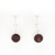 A pair of silver leverback drop earrings with round dark red garnet gemstones, shown against a plain white background.
