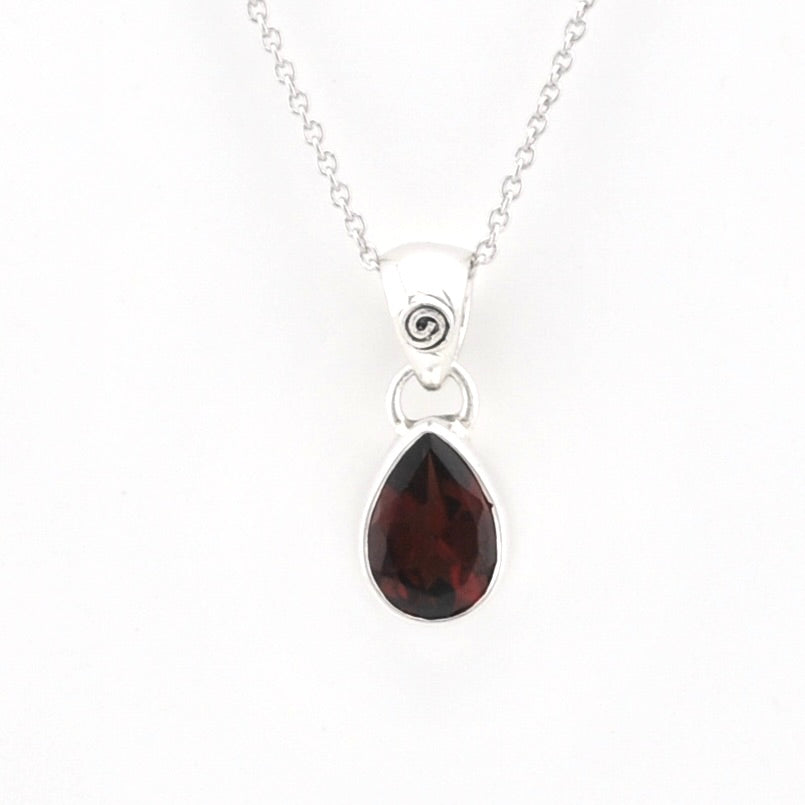A silver pendant necklace featuring a teardrop-shaped dark red gemstone, shown against a plain white background.