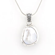 A sterling silver pendant necklace featuring a large, irregularly shaped white mother-of-pearl bead set in a polished silver bezel, suspended from a fine silver snake chain. The pendant is displayed against a clean, solid white background.