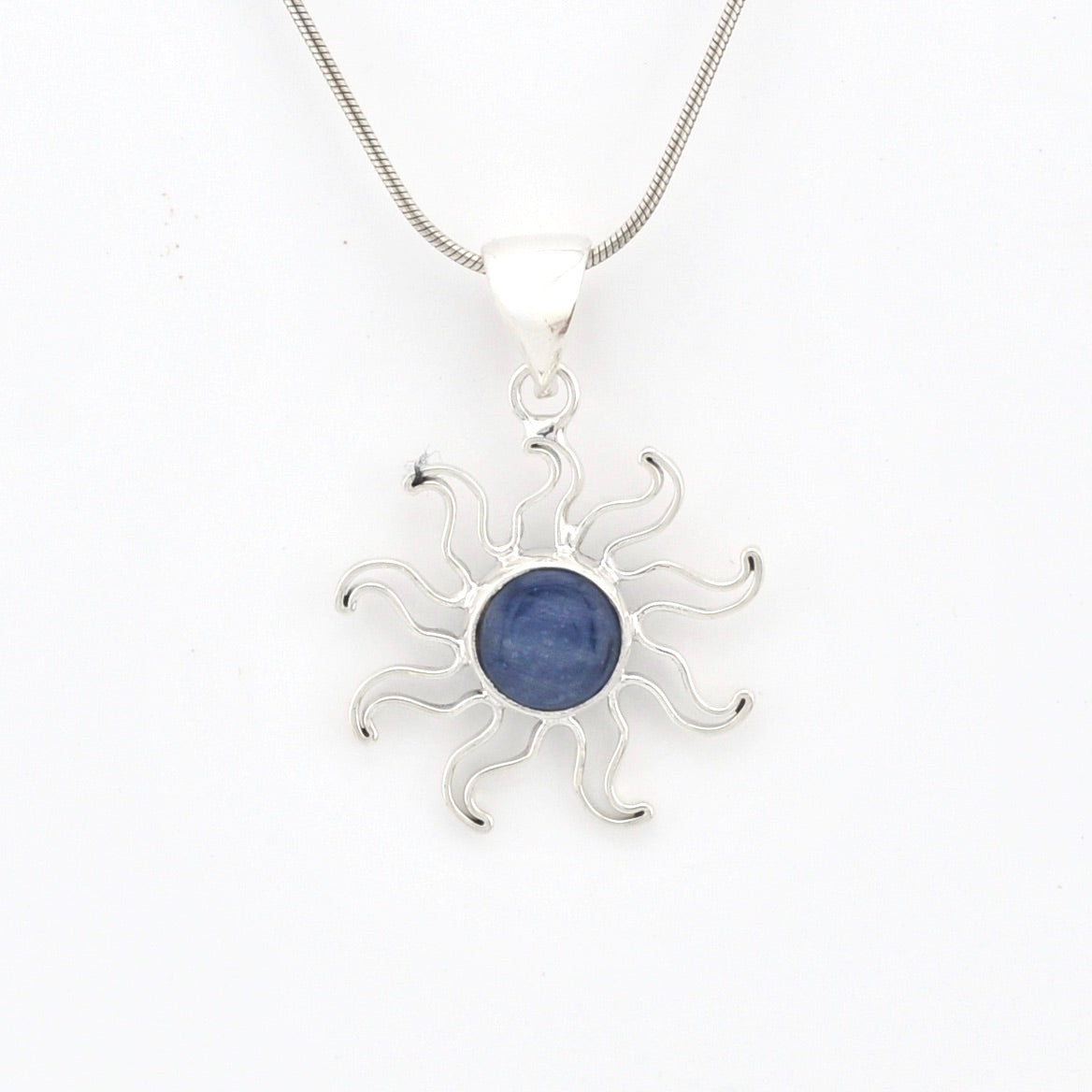 Silver sun-shaped pendant with a blue gemstone on a white background