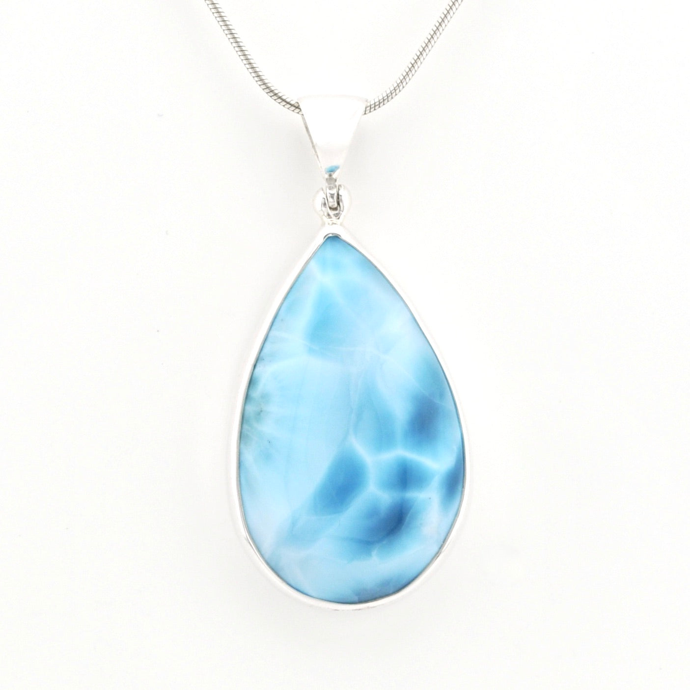 A teardrop-shaped pendant necklace featuring a light blue marbled gemstone in a silver bezel setting, suspended from a silver snake chain against a plain white background.