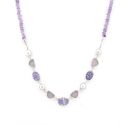 A beaded necklace featuring light purple amethyst beads, white pearls, and gray sea glass pieces set in silver-tone metal, displayed on a clean white background.