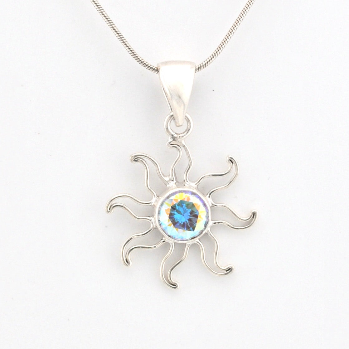 Silver sun-shaped pendant with a blue gemstone on a white background