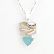A silver pendant necklace featuring a rectangular inlay with natural shell and a hanging sea glass triangle below, shown on a white background.