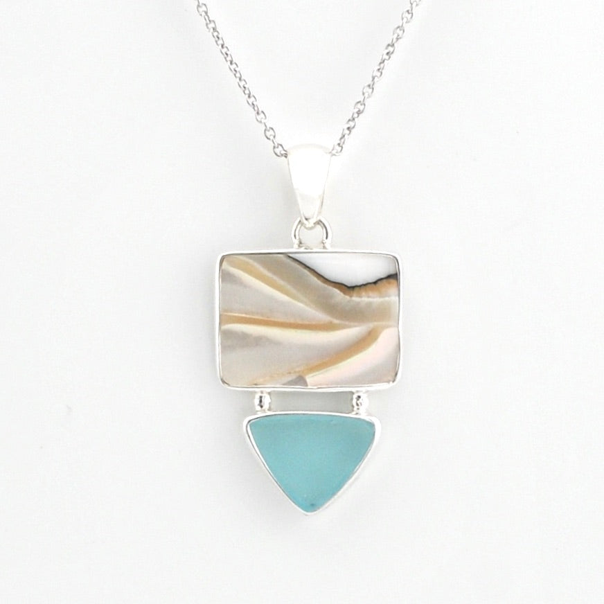 A silver pendant necklace featuring a rectangular inlay with natural shell and a hanging sea glass triangle below, shown on a white background.