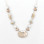 Necklace with pearls and shell-like beads on a white background