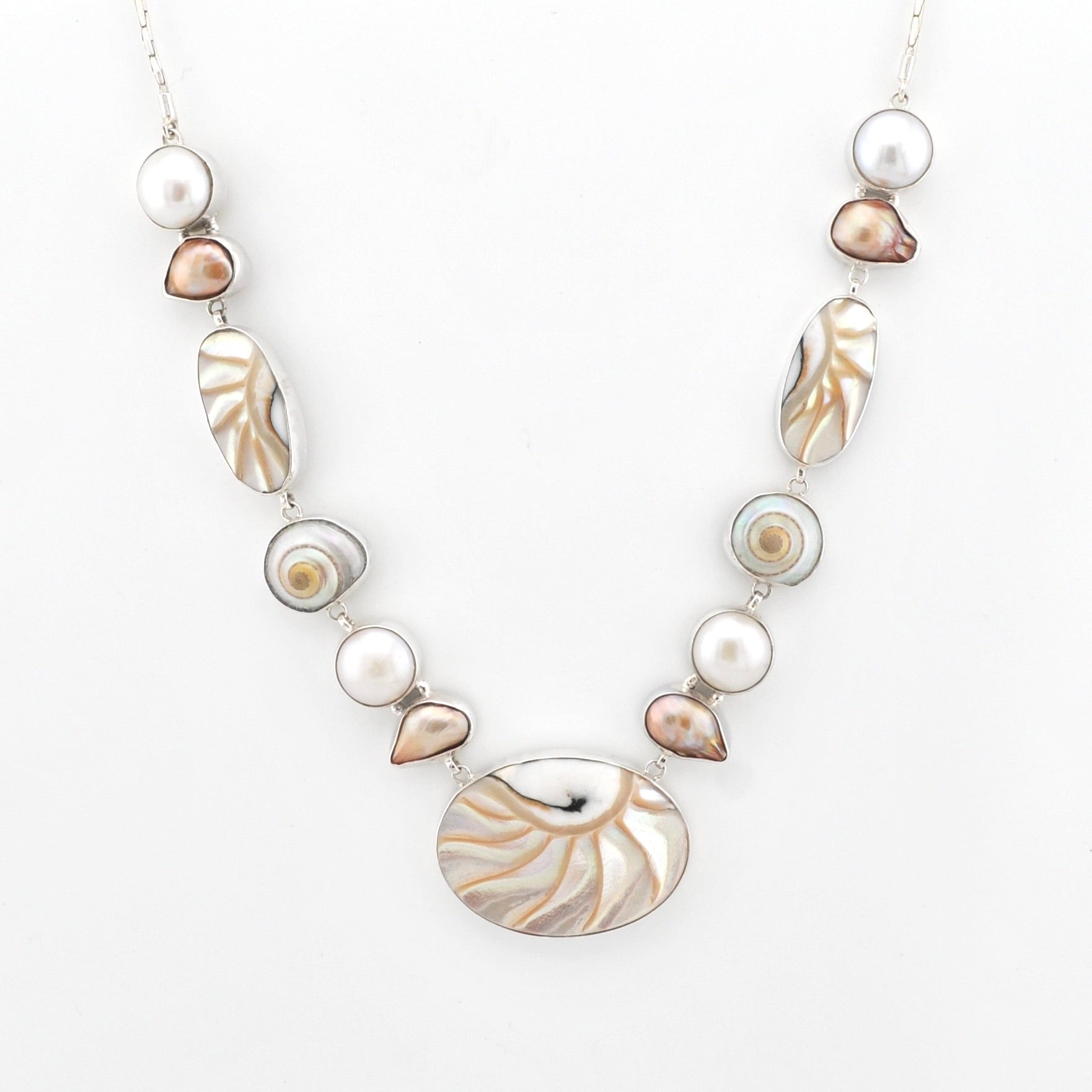 Necklace with pearls and shell-like beads on a white background
