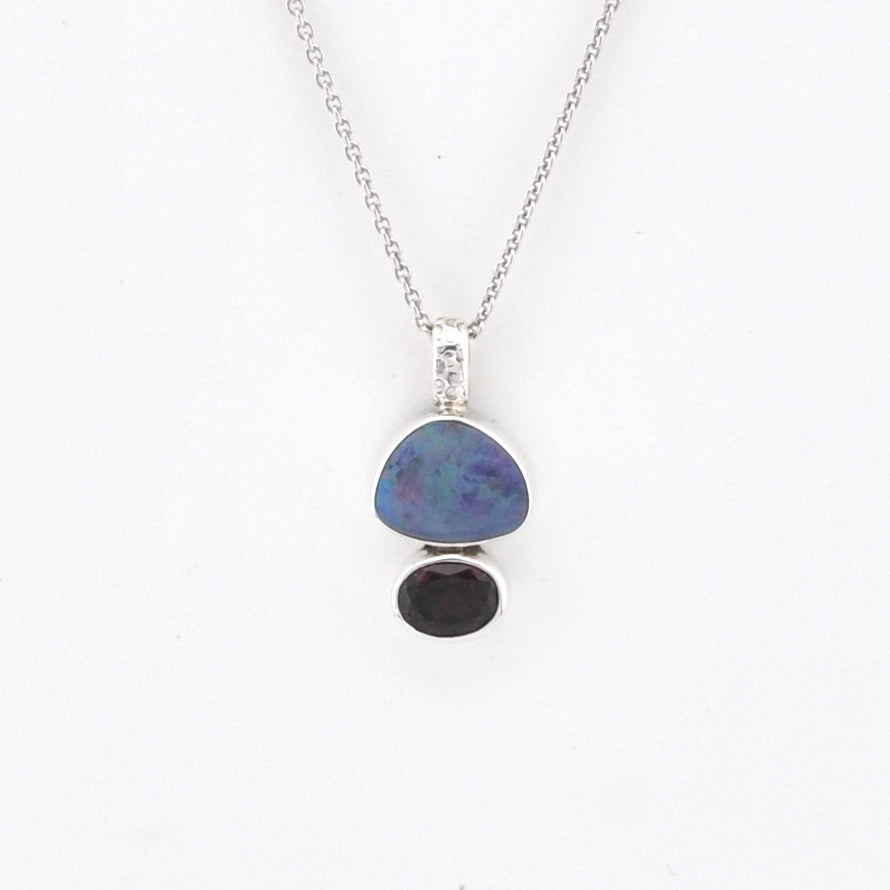 Opal and Garnet pendant with chain on white background.