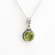 Silver necklace with a green gemstone pendant on a white background