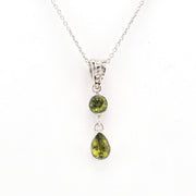 Silver necklace with two green gemstone pendants on a white background