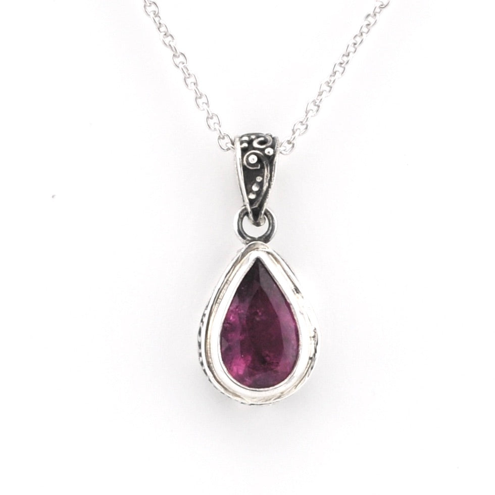 Pink tourmaline teardrop pendant on cahin on white background
