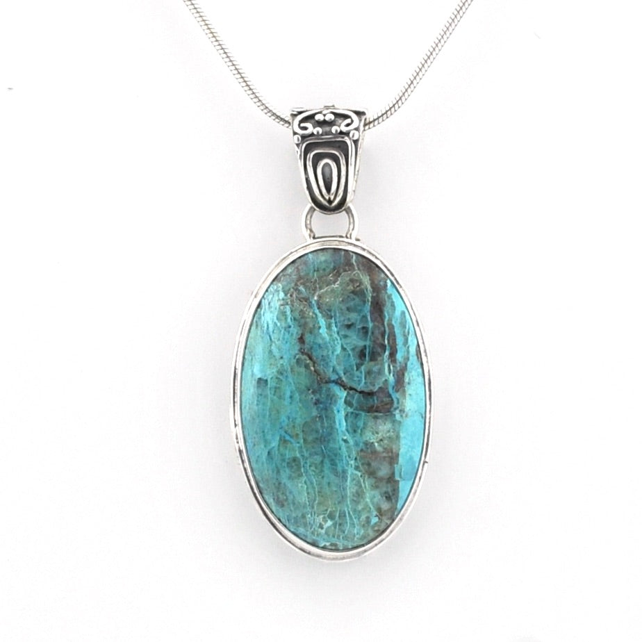 An oval pendant necklace featuring a turquoise-blue marbled stone in a silver bezel setting, suspended from a silver snake chain against a plain white background.