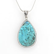 A teardrop-shaped turquoise pendant necklace in a silver bezel setting on a delicate silver chain, shown against a plain white background.