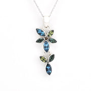 A silver pendant necklace featuring marquise-cut blue and green gemstones arranged in a leafy vine design, shown against a plain white background.