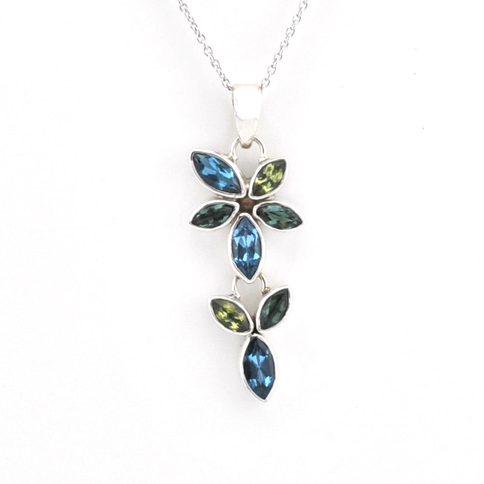 A silver pendant necklace featuring marquise-cut blue and green gemstones arranged in a leafy vine design, shown against a plain white background.