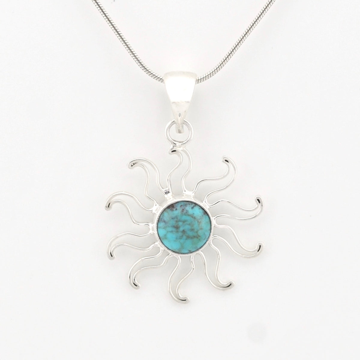 A sterling silver sunburst pendant necklace featuring a round turquoise stone in the center, suspended from a delicate silver chain against a plain white background.