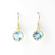 Gold earrings with blue gemstones on a white background
