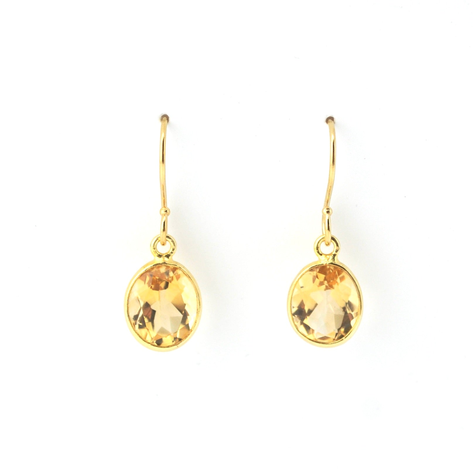 Gold earrings with citrine stones on a white background