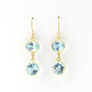 Gold earrings with blue gemstones on a white background