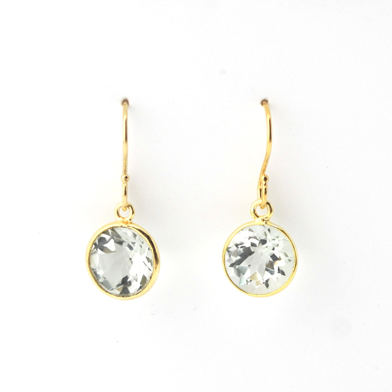 Gold earrings with clear gemstones on a white background