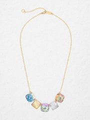 Necklace with colorful crystal pendants on a light gray background