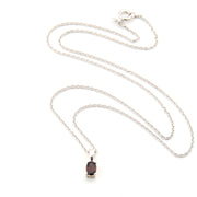 Silver necklace with a dark gemstone pendant on a white background