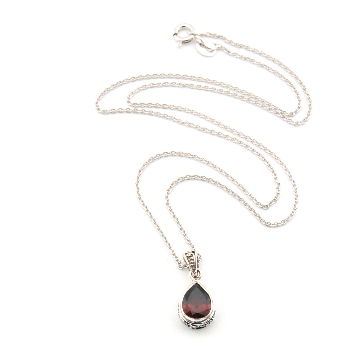 Silver necklace with a teardrop-shaped pendant on a white background