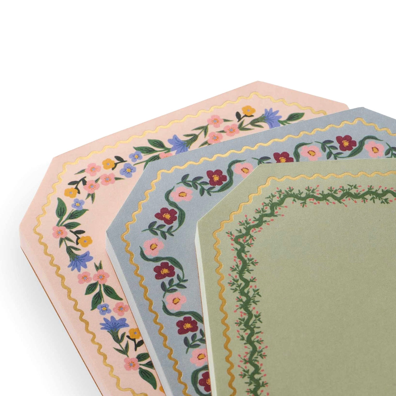 Set of three hexagonal placemats with floral patterns on a white background