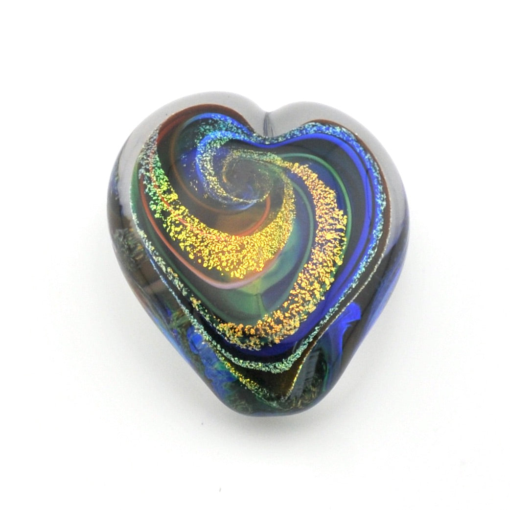Heart-shaped glass paperweight with multicolored swirl pattern on a white background