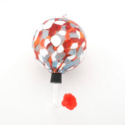 Decorative hummingbird feeder with red and silver design on a white background