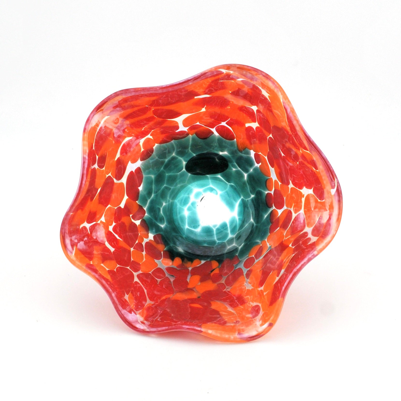 Glass sculpture with orange and red patterns on a white background