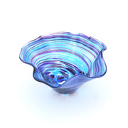 Blue glass bowl with wavy design on a white background