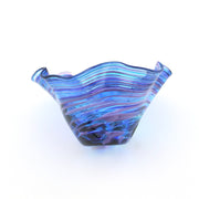 Blue glass bowl with wavy pattern on a white background