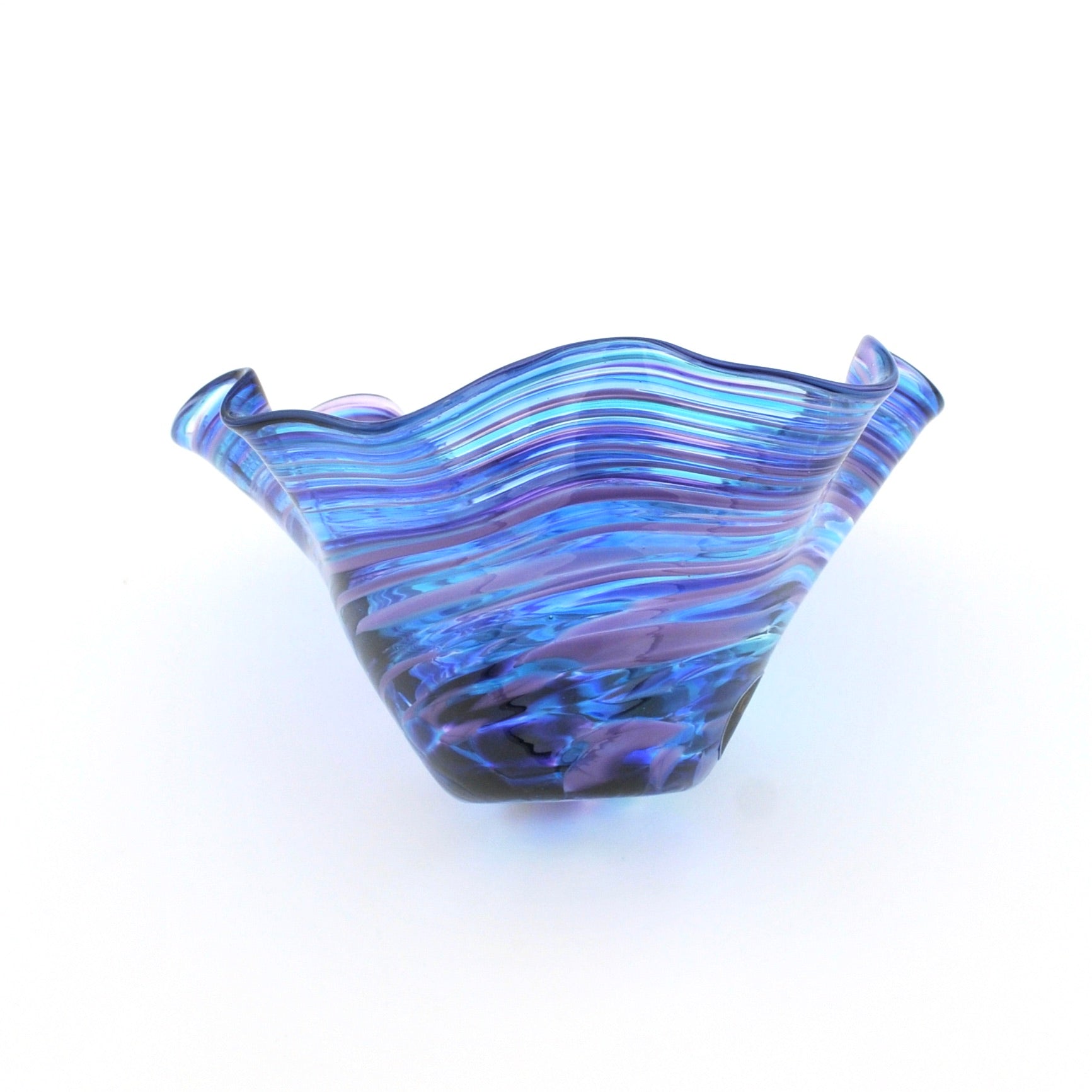 Blue glass bowl with wavy pattern on a white background