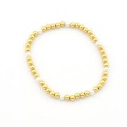 A beaded stretch bracelet featuring alternating shiny gold metallic beads and smooth white pearl-like beads, displayed on a clean white background.